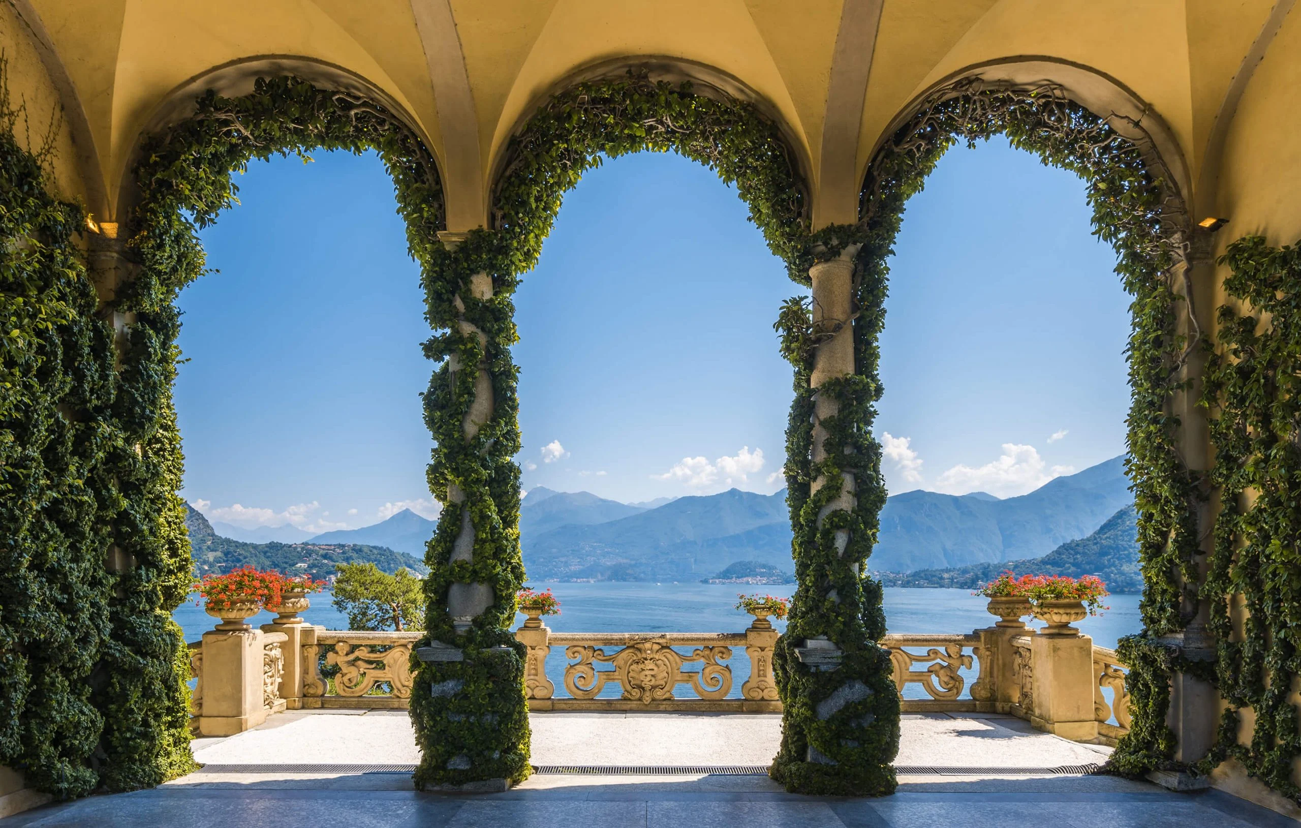 Ivy-covered stone arches framing a lake view