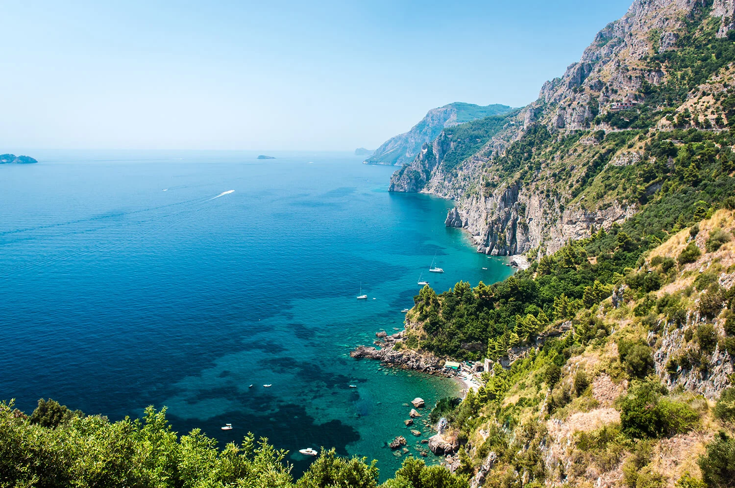 Cliffside coastline above clear blue water