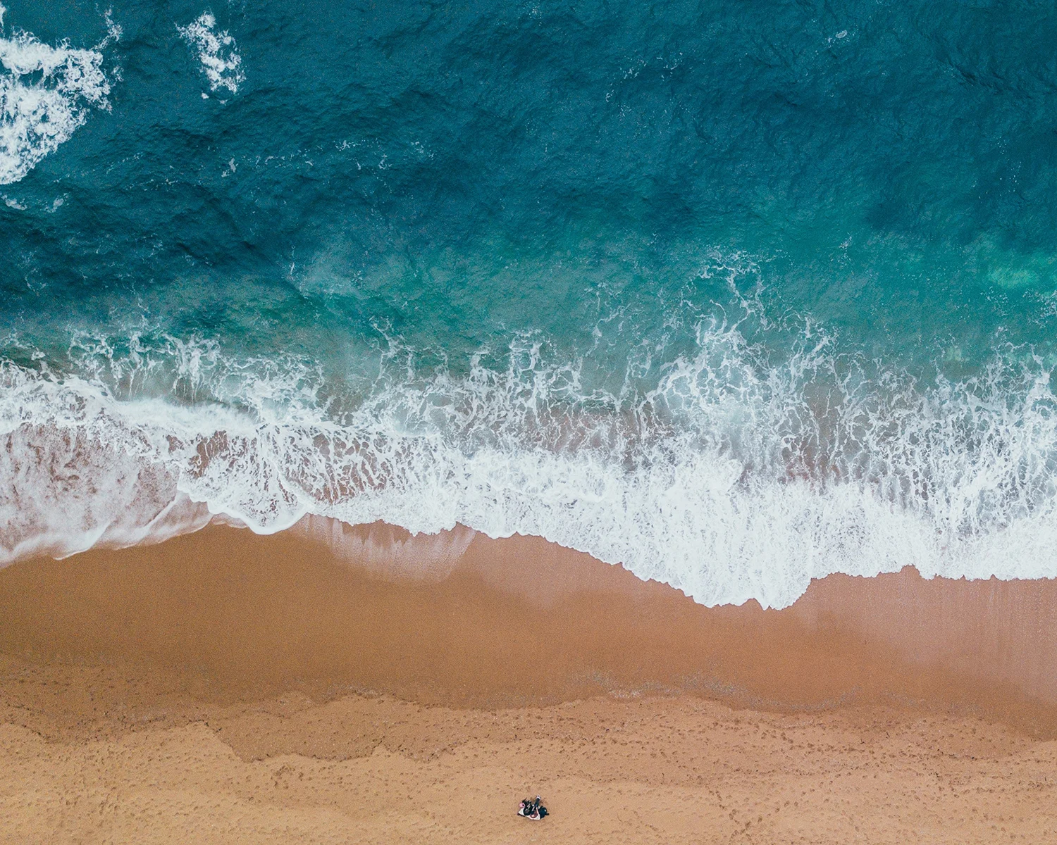 Turquoise waves breaking on a pale sand beach
