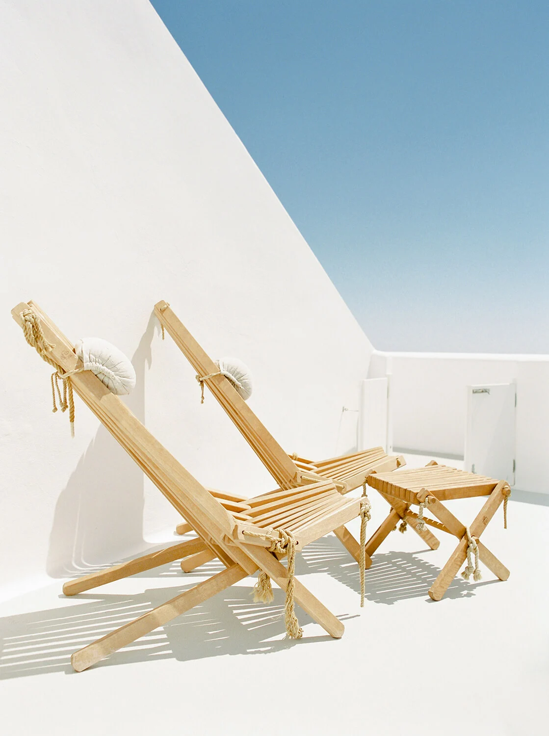 Wooden deck chairs on a white terrace